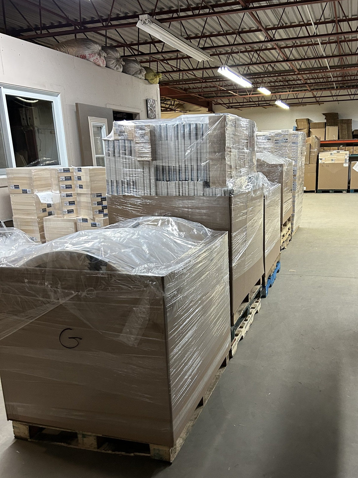 Multiple wrapped pallets of artist canvases in the Apollon shipping area