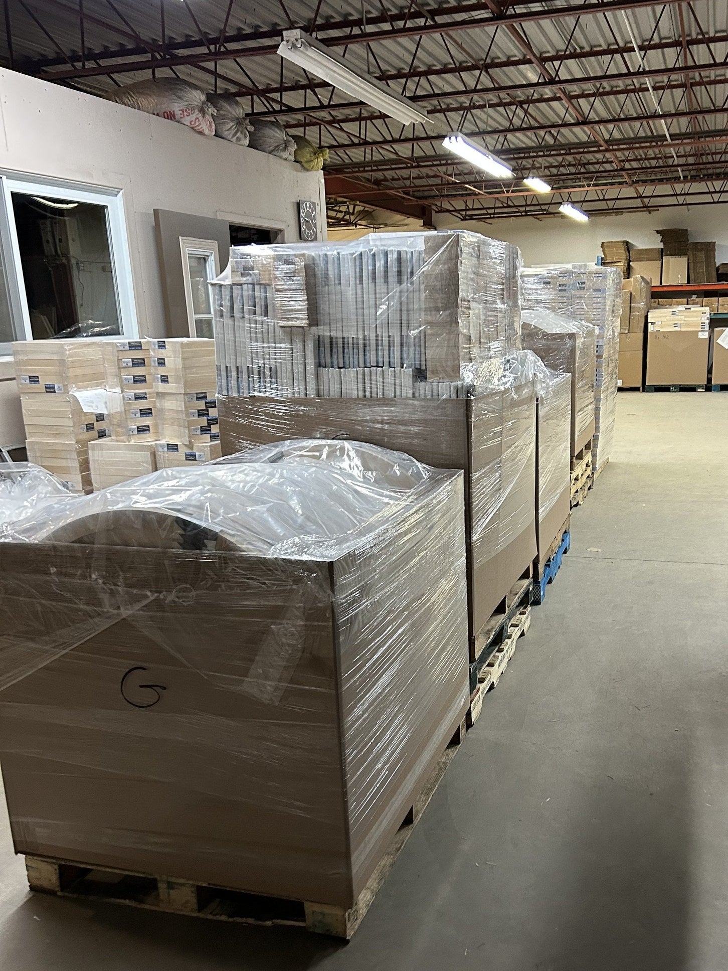 Multiple wrapped pallets of artist canvases in the Apollon shipping area
