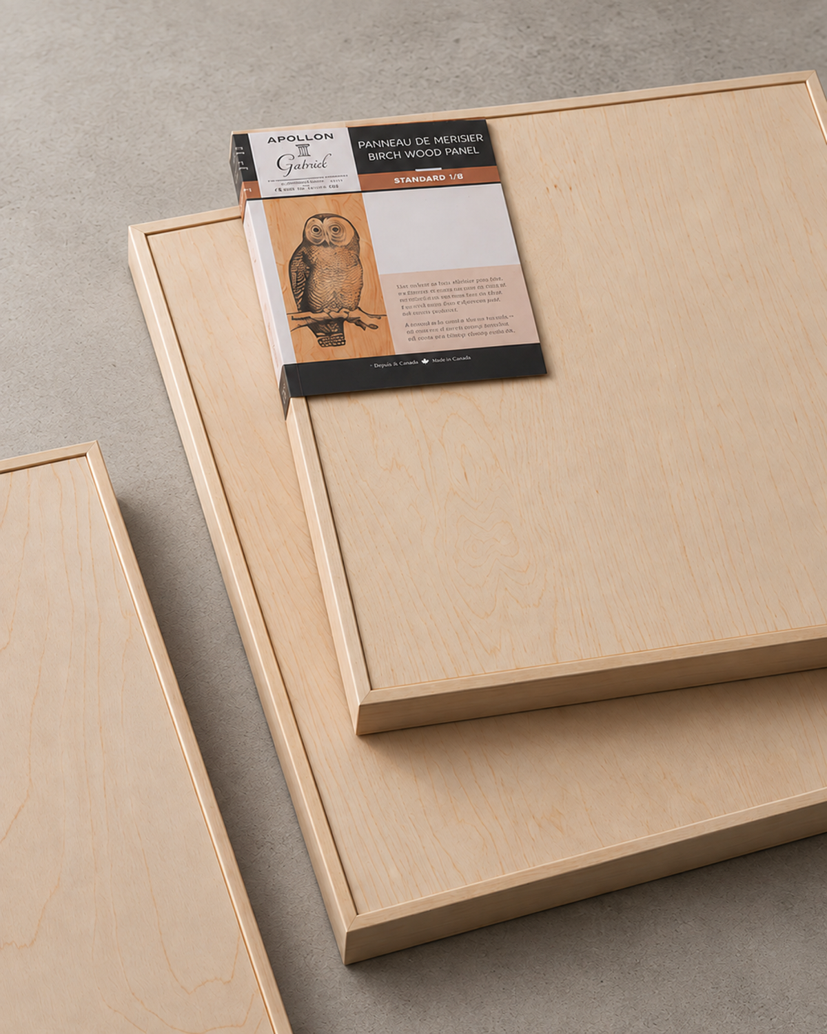 Smooth liquid art panels with cradled wood edges arranged on a concrete surface.