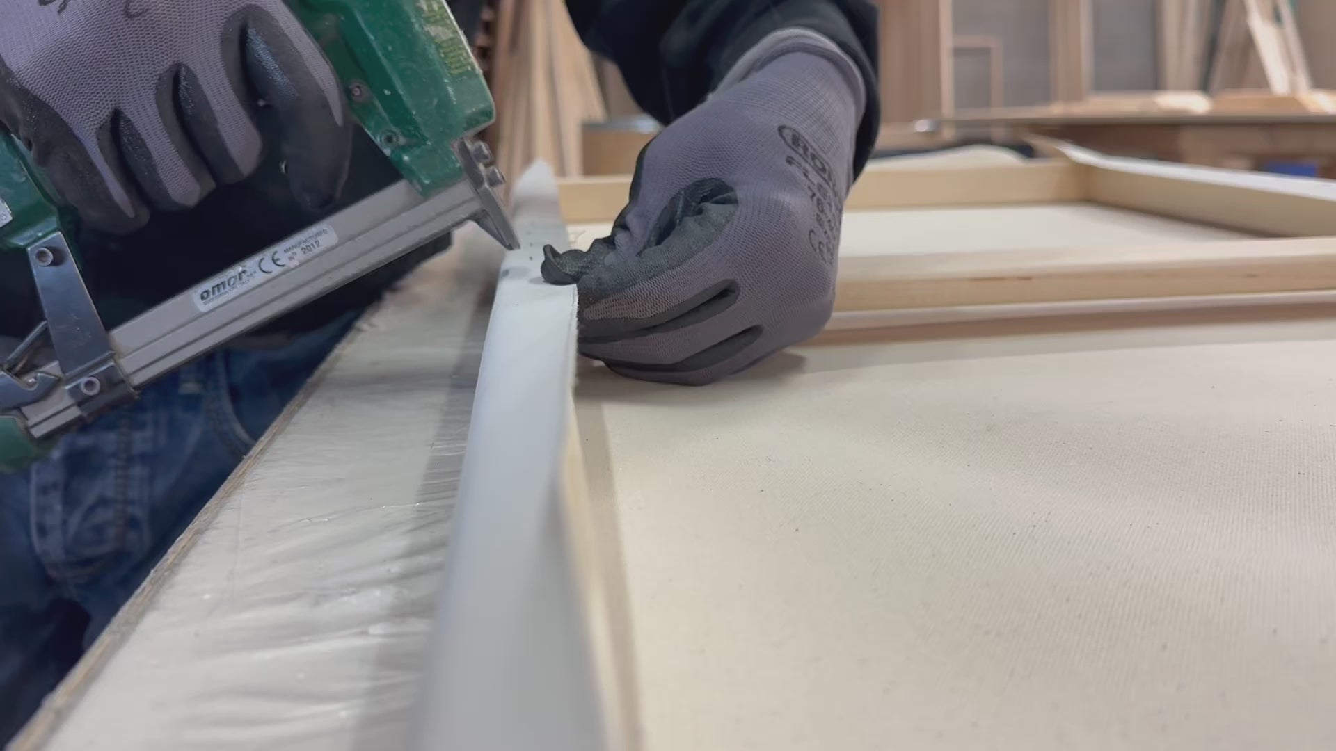 A worker stretches canvas in the Apollon workshop