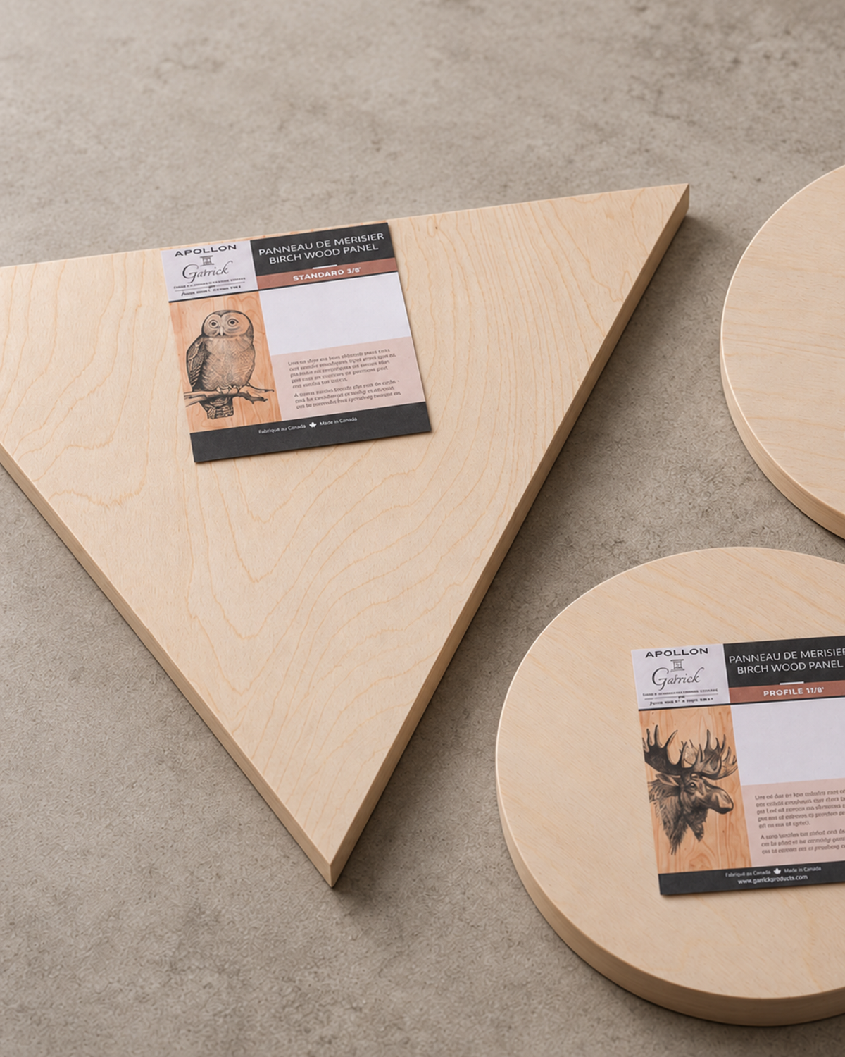 Round and triangular birch wood artist panels arranged on a neutral surface.